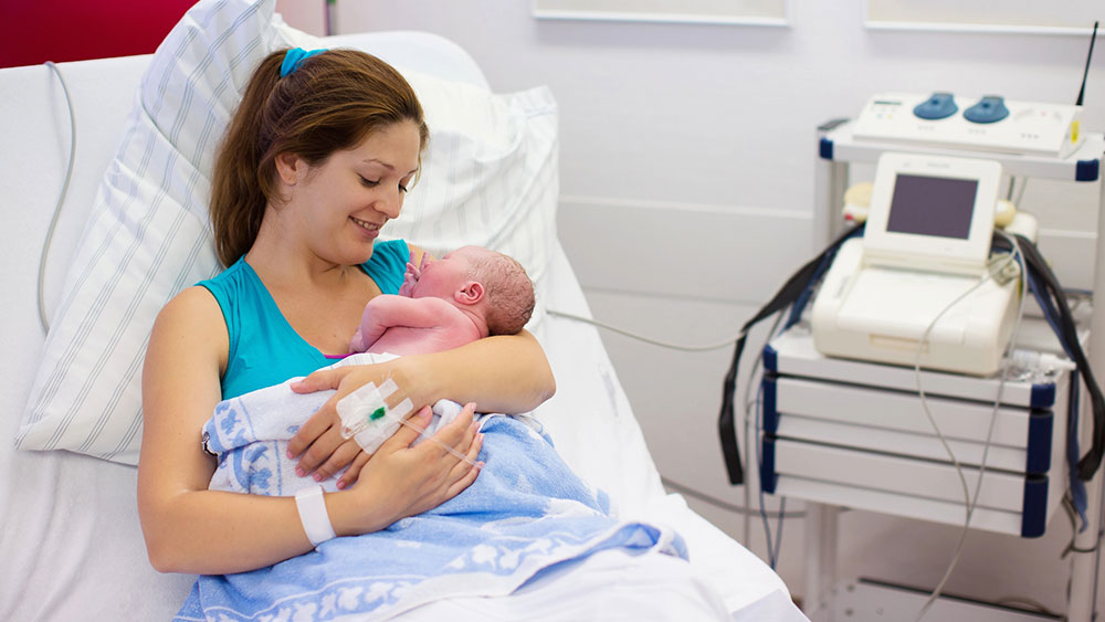Young mother with newborn baby in hospital