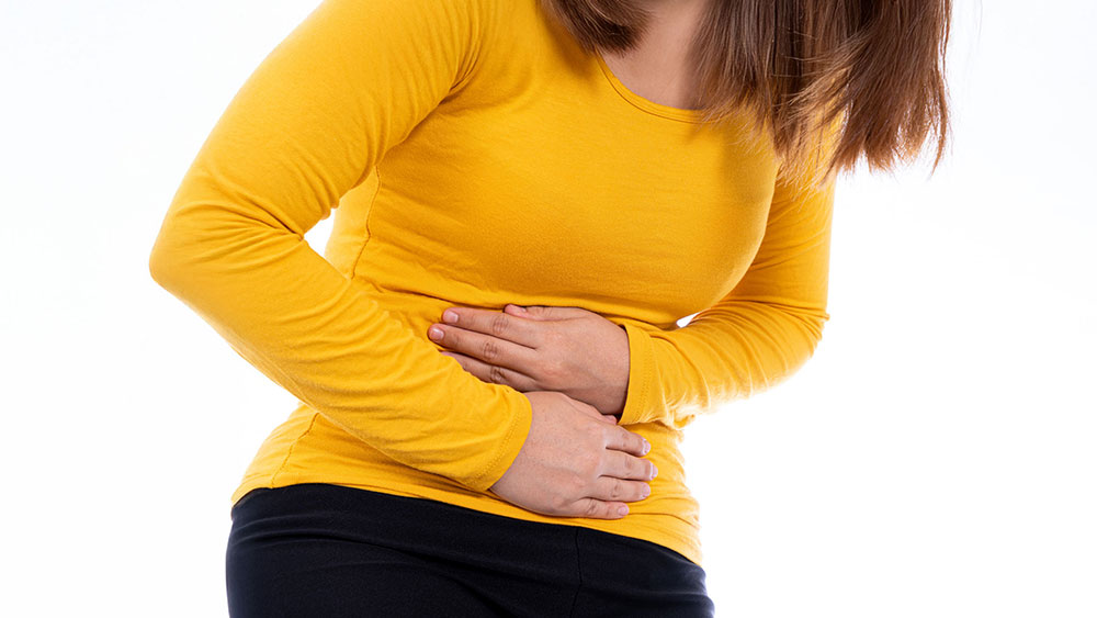 Woman suffering from stomach pain caused by an adhesion in the abdomen.