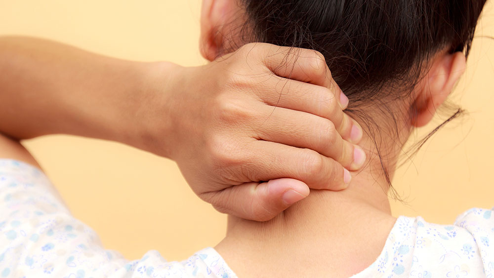 Woman rubs her painful neck