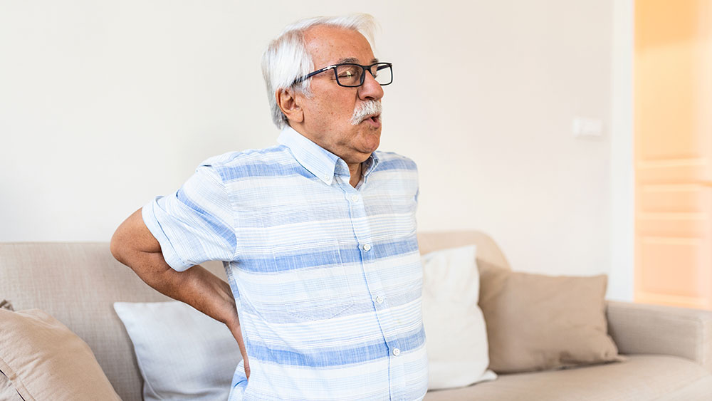 Senior man suffering lower back pain caused by lumbar spinal stenosis