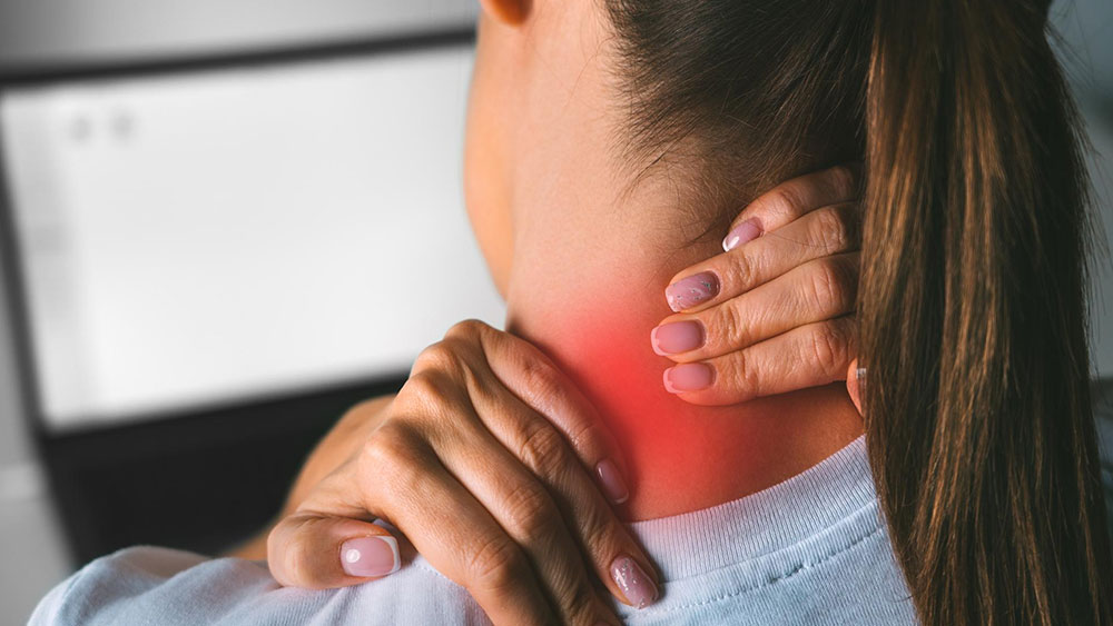 What Is Cervical Radiculopathy (Pinched Nerve)? Symptoms and Treatments A young woman massaging her neck to relieve pain after working on a PC